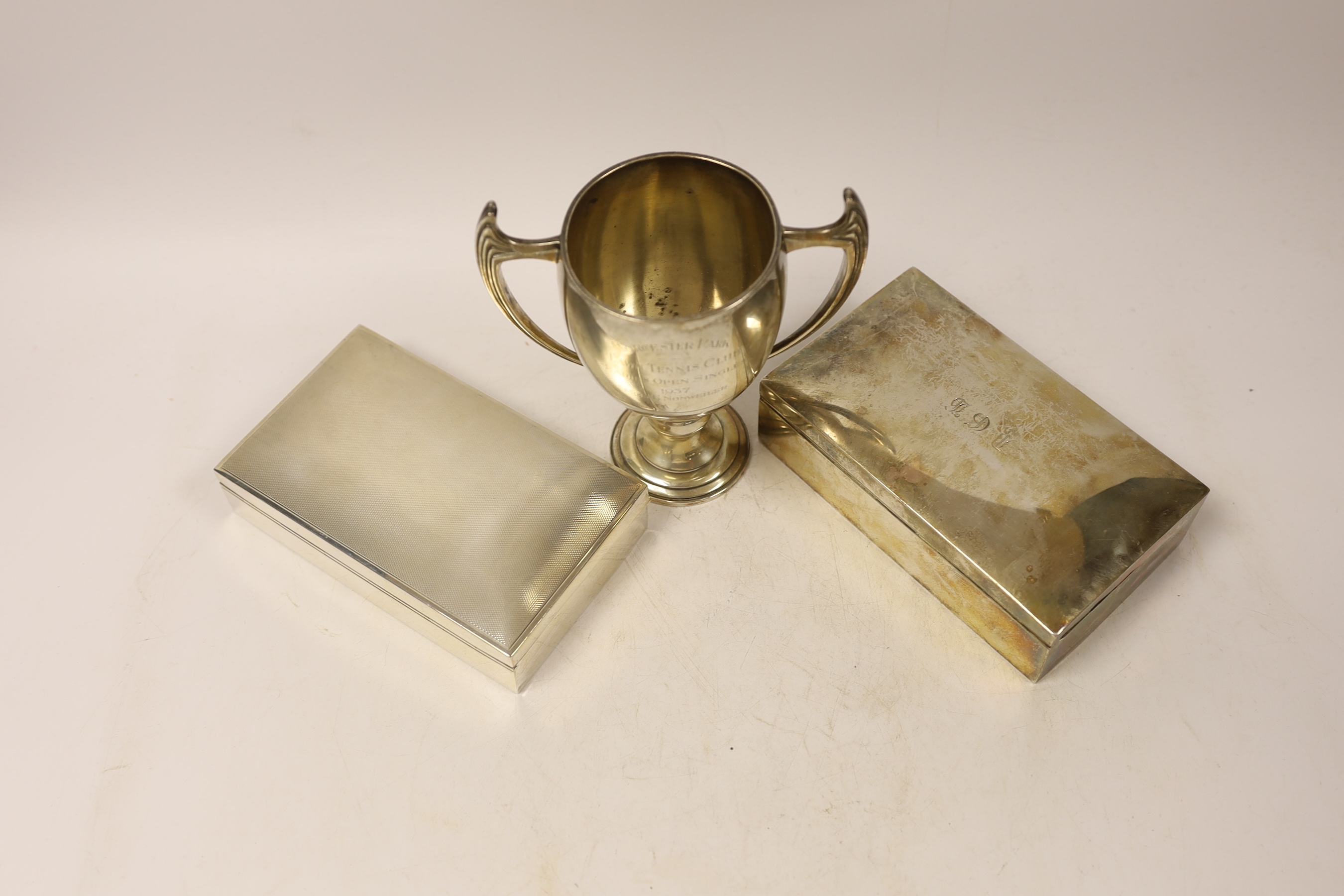 A 1930's Art Deco silver two handled presentation trophy cup, by Mappin & Webb, 15.6cm, and two silver mounted rectangular cigarette boxes.